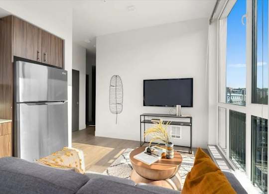 A modern living room with a grey sofa and a wooden coffee table.