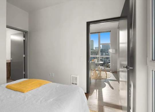 A bedroom with a large bed and a view of the city.