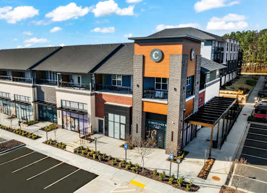 A modern building with a parking lot in front.