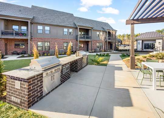 A sunny day at a residential complex with a walkway and greenery.