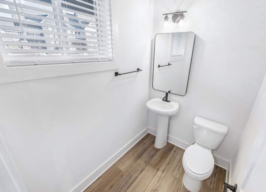 A white toilet and sink in a small bathroom.