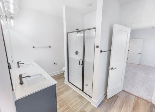 A bathroom with a sink, mirror, and shower.
