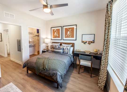 A bedroom with a bed, desk, and chair.