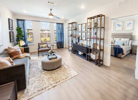 A living room with a large window, a couch, a coffee table, and a TV.