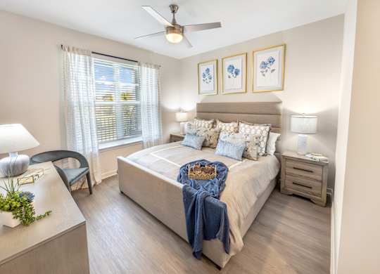 A bedroom with a bed, nightstand, and chair.