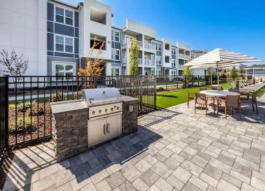 A patio with a table and chairs is in front of a building.