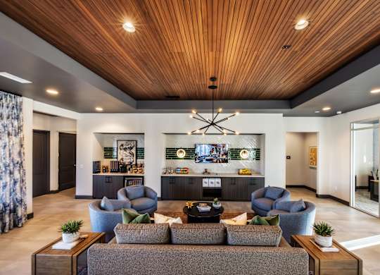 A modern living room with a wooden ceiling and a large sectional sofa.