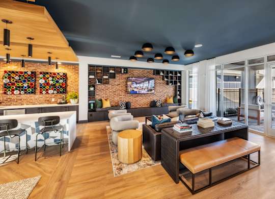 A modern living room with a brick wall and a flat screen TV.