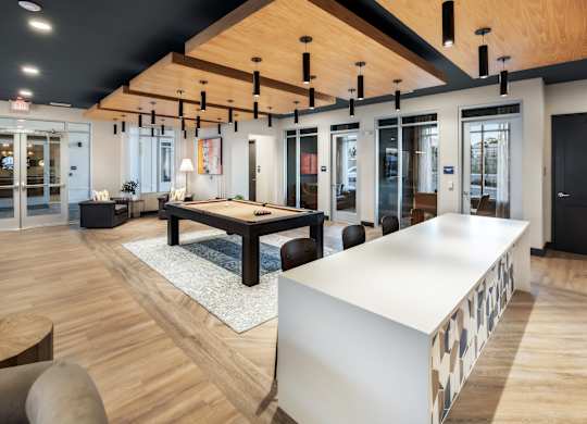 A modern office space with a long white table and wooden floors.