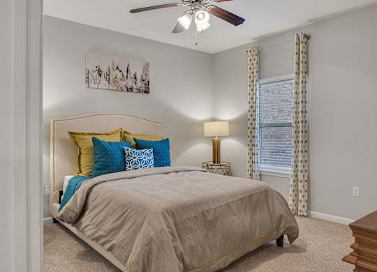 A bedroom with a bed, pillows, a ceiling fan, and a painting on the wall at Echo at Lake Norman, Mooresville