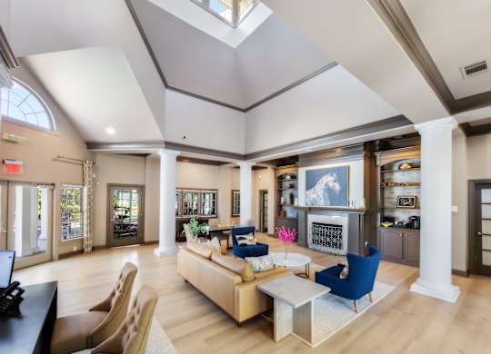 A spacious living room with a skylight, a blue sofa, and a coffee table.