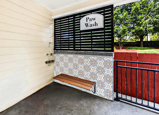 A Paw Wash sign is on a black and white patterned wall.