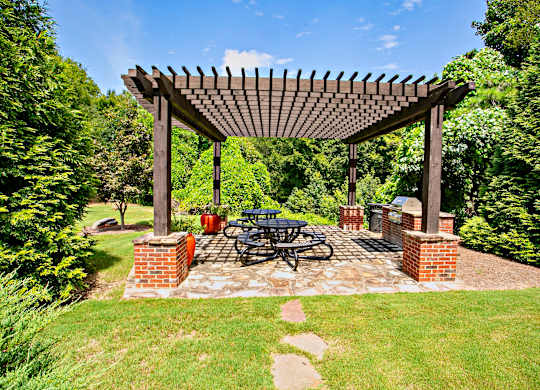A wooden pergola with a bicycle parked under it.