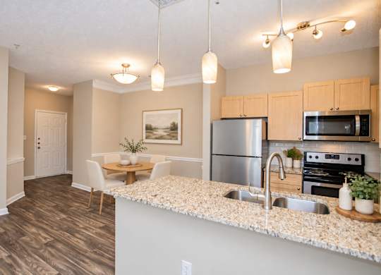 A kitchen with a stainless steel refrigerator, microwave, and oven.