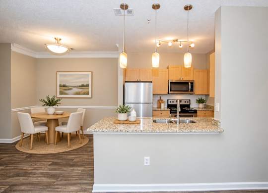 A kitchen with a dining table and chairs.