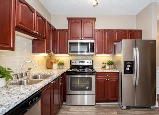A kitchen with brown cabinets and stainless steel appliances.