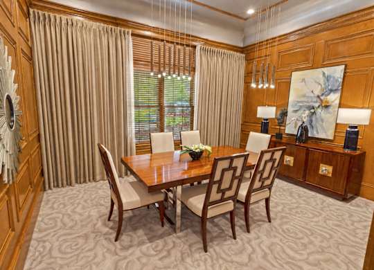 A dining room with a wooden table and chairs.
