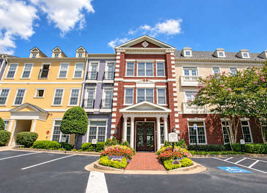 A large, multi-story building with a red brick facade and a white entrance.