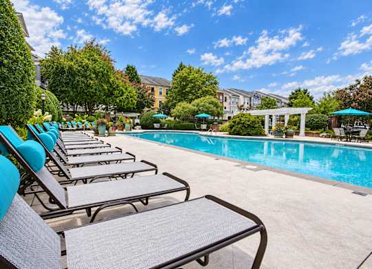A pool with chairs around it.