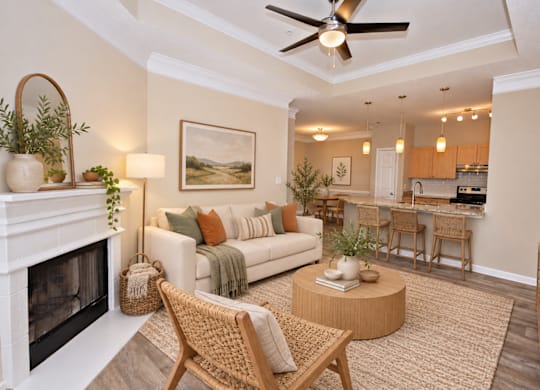 A living room with a fireplace, a sofa, a chair, and a painting on the wall.