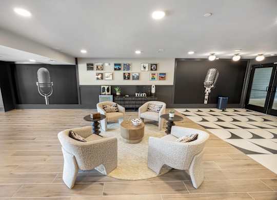 A modern living room with a large speaker and a collection of framed pictures on the wall.