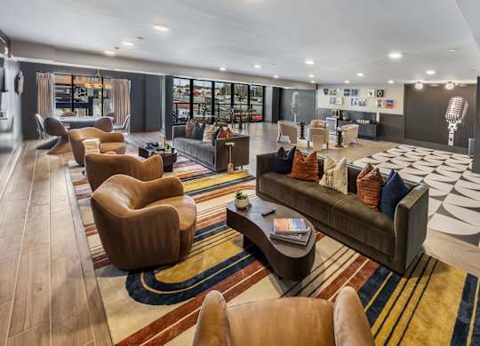 A modern living room with a variety of seating options and a large rug.