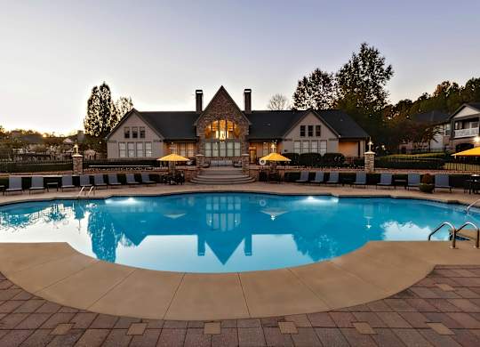 A large house with a pool in front of it.