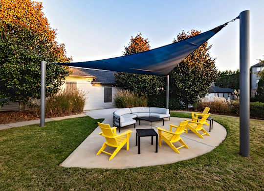 A patio with a table and chairs under a canopy.