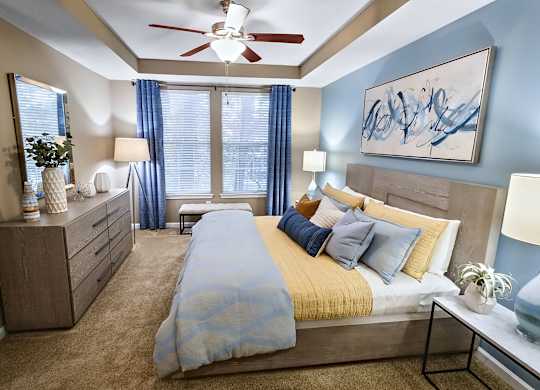 A bedroom with a bed, nightstands, and a ceiling fan.