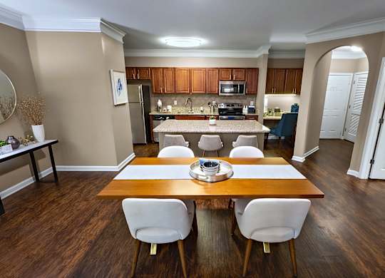 A kitchen with a table and chairs in the foreground.