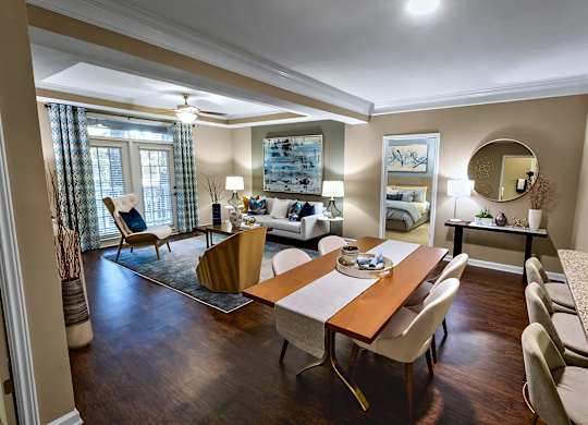 A well-lit, spacious living room with a dining table and chairs.