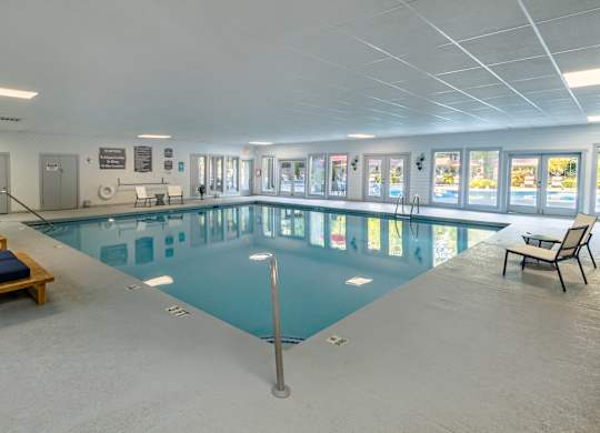 a large indoor swimming pool with lounge chairs and tables at Seven Pines, Alpharetta, GA