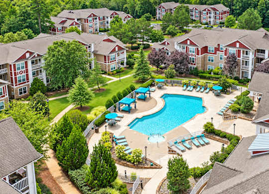 An aerial view of a resort with a swimming pool and multiple buildings.