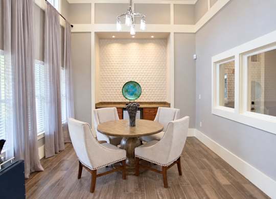 A dining room with a round table and chairs.