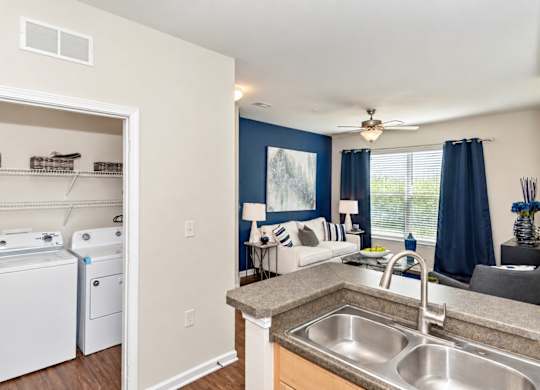 A kitchen with a washer and dryer in the laundry room.