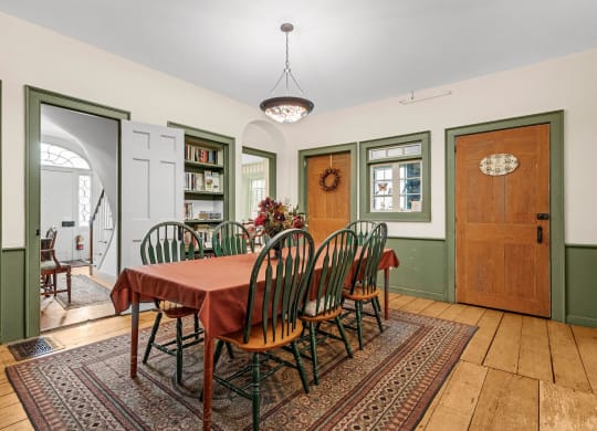 a dining room with a table and chairs and green walls
