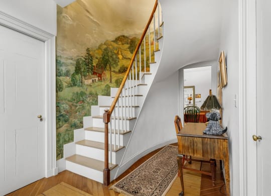 a staircase with a mural on the wall next to a door