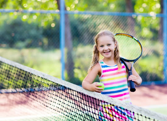 little girl playing tennis