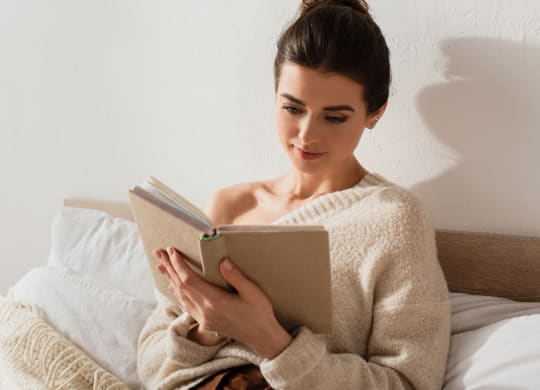 woman reading a book in bed