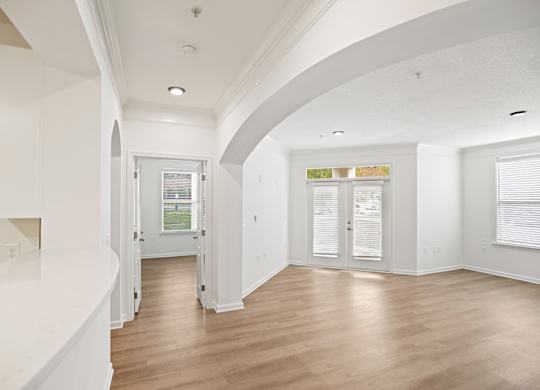 A white interior with wood floors and a window.