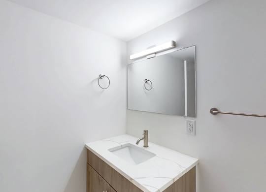 A bathroom with a white sink and a mirror above it.