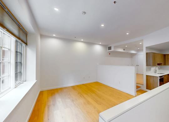A room with a white wall and a wooden floor.