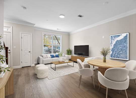 A living room with a white couch, a wooden coffee table, and a large painting on the wall.