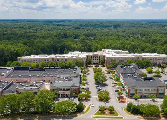 A large building complex with a parking lot in front.