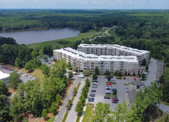 A large white building with a parking lot in front of it.