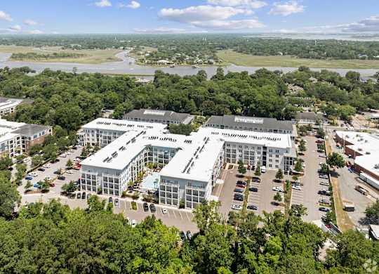 A large building complex with a parking lot in front.