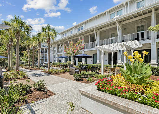 A sunny day at a resort with a walkway and buildings in the background.
