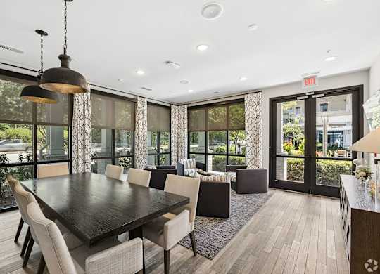 A dining room with a large table and chairs.