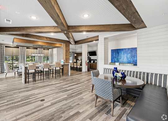 A large room with a wooden floor and a long table with chairs.