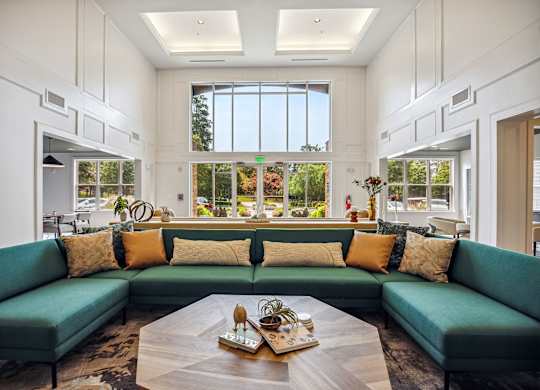 A living room with a green couch and a coffee table in the center.